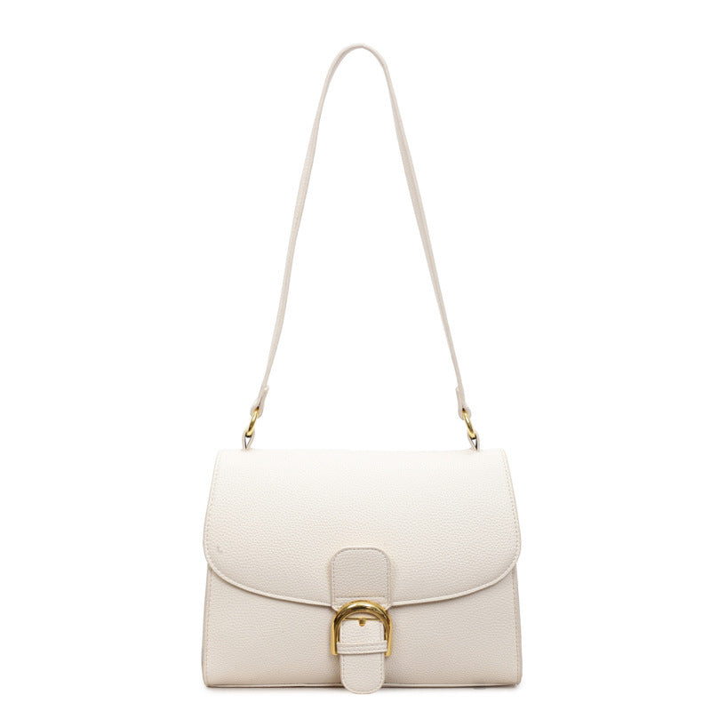 Ladies shoulder bag with elegant flap closure and decorative metal accent
