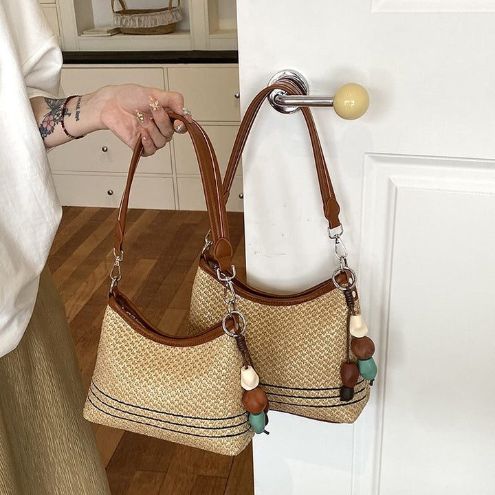 Women's shoulder bag made of woven natural material with decorative pendant