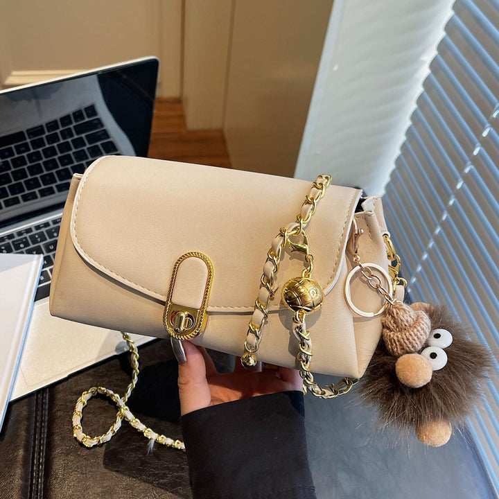 Women's shoulder bag with decorative pendant and luxurious chain strap