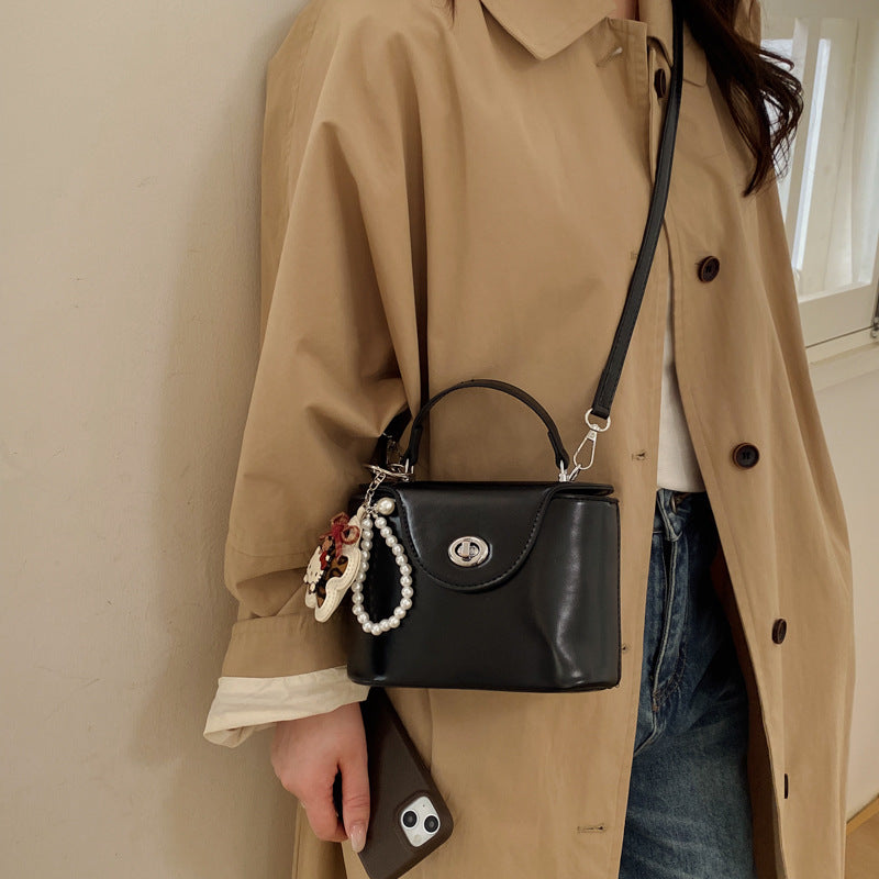 Ladies mini handbag in elegantly curved design with playful pendant