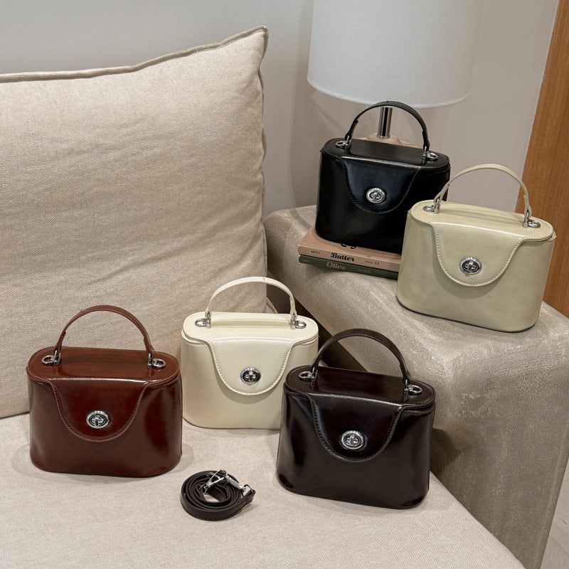Ladies mini handbag in elegantly curved design with playful pendant