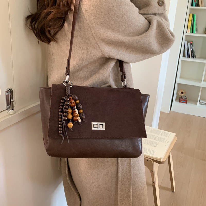 Women's elegant shoulder bag made of high-quality faux leather with playful charm