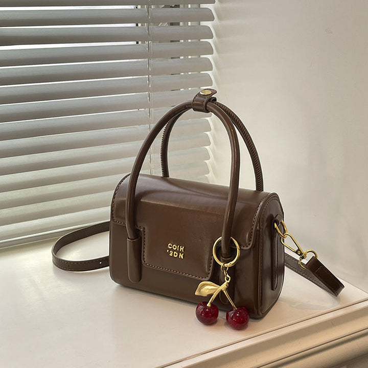 Women's mini handbag with elegant structure and charming pendant