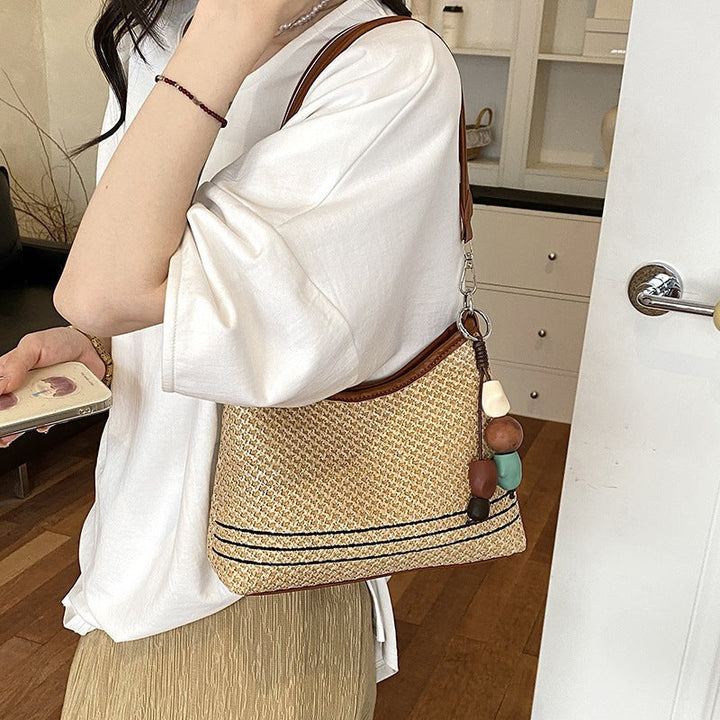 Women's shoulder bag made of woven natural material with decorative pendant