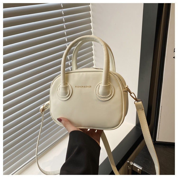 Ladies fashionable handbag with elegant pull handles and removable shoulder strap