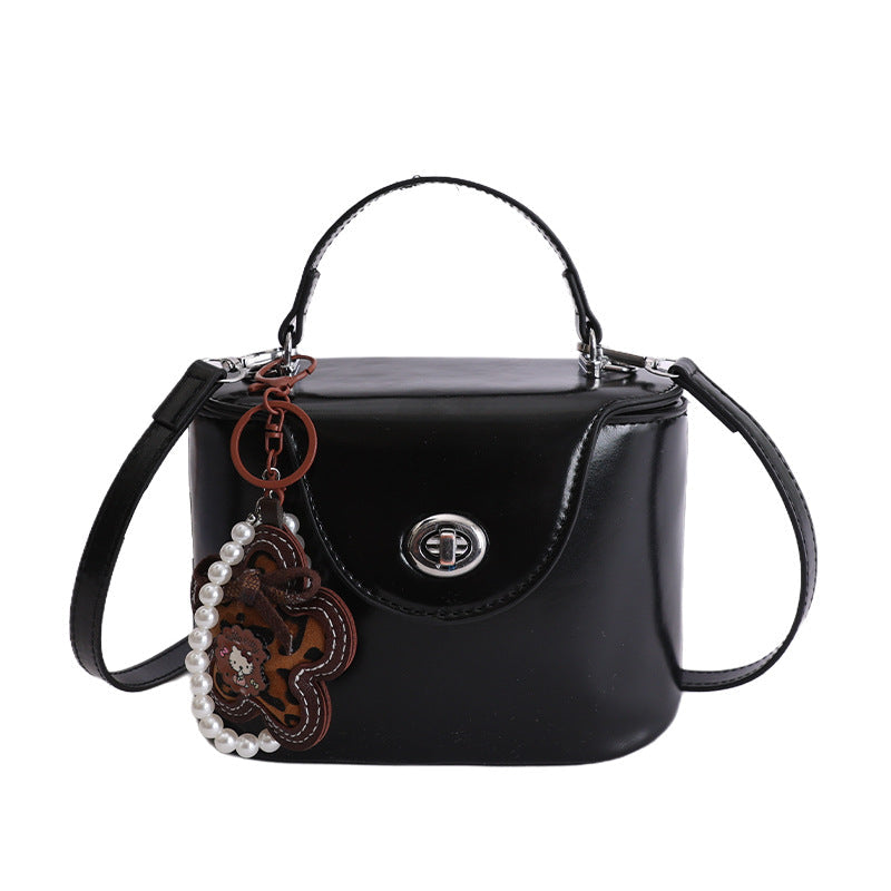 Ladies mini handbag in elegantly curved design with playful pendant