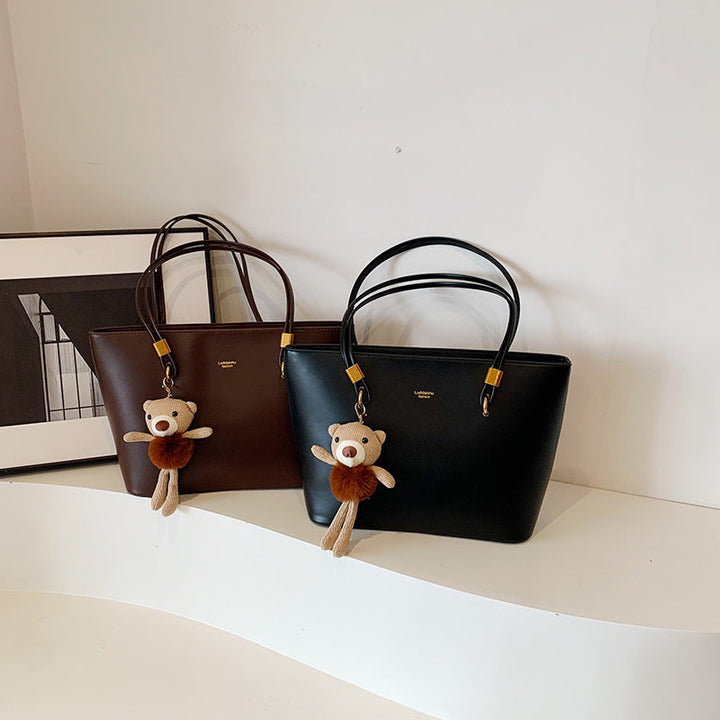 Women's tote bag made of high-quality artificial leather with a charming pendant from