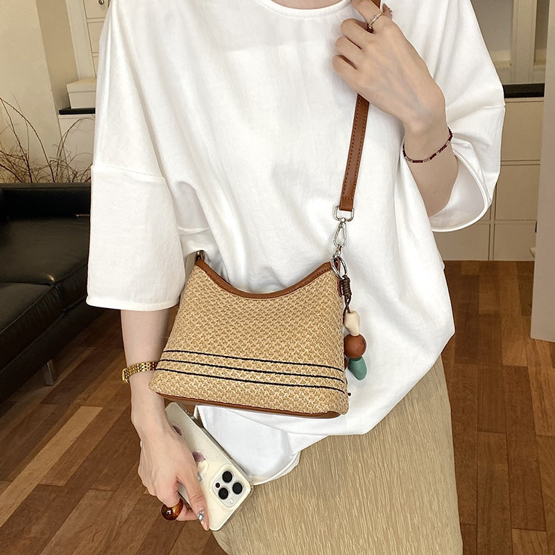 Women's shoulder bag made of woven natural material with decorative pendant