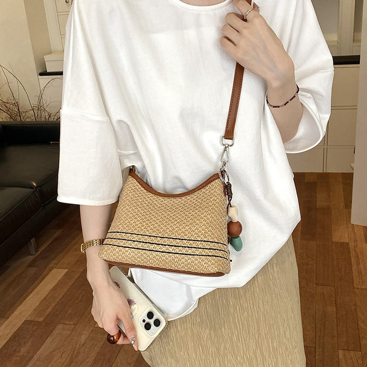 Women's shoulder bag made of woven natural material with decorative pendant