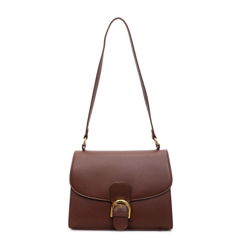 Ladies shoulder bag with elegant flap closure and decorative metal accent