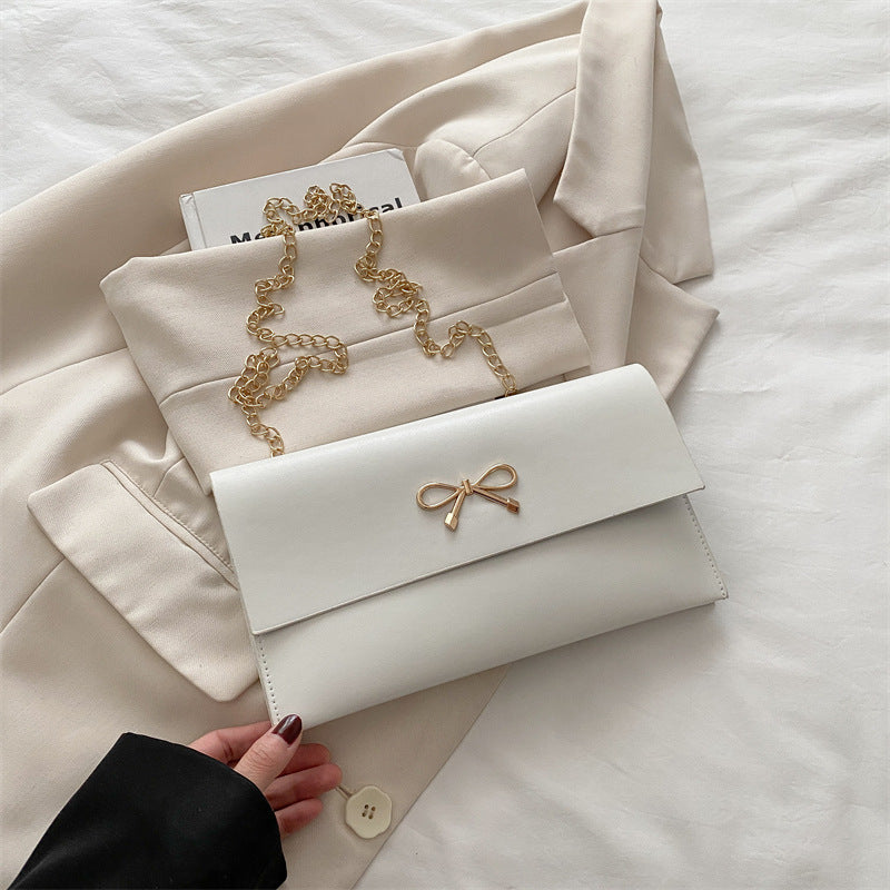 Women's elegant clutch in minimalist design with golden accents