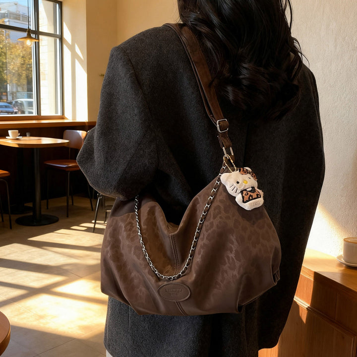 Ladies elegant hobo bag made of structured synthetic leather with detachable tag