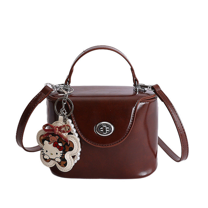 Ladies mini handbag in elegantly curved design with playful pendant