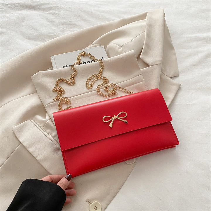 Women's elegant clutch in minimalist design with golden accents