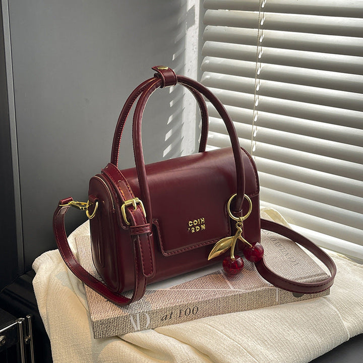 Women's mini handbag with elegant structure and charming pendant