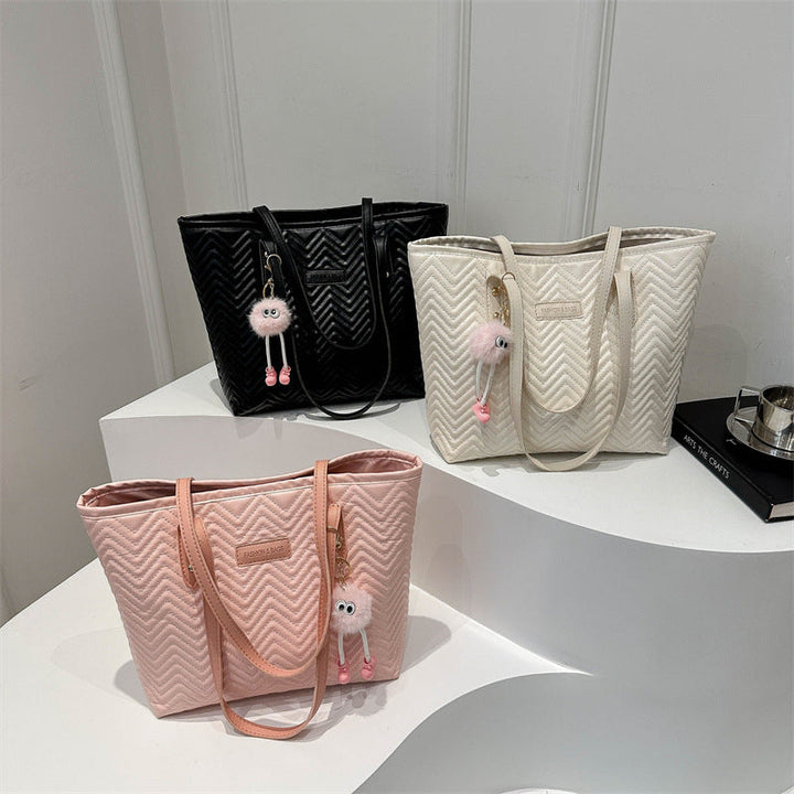 Women's leisure tote bag with textured wave pattern and charming pendant