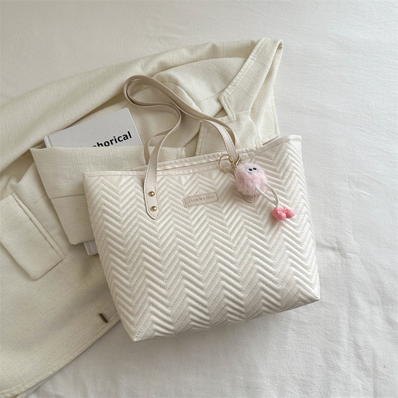 Women's leisure tote bag with textured wave pattern and charming pendant