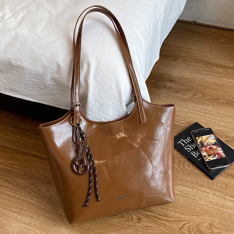 Ladies elegant tote handbag made of high-quality synthetic leather with playful pendant