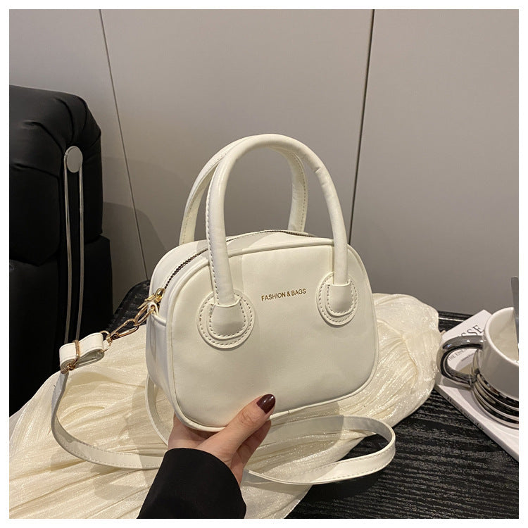Ladies fashionable handbag with elegant pull handles and removable shoulder strap