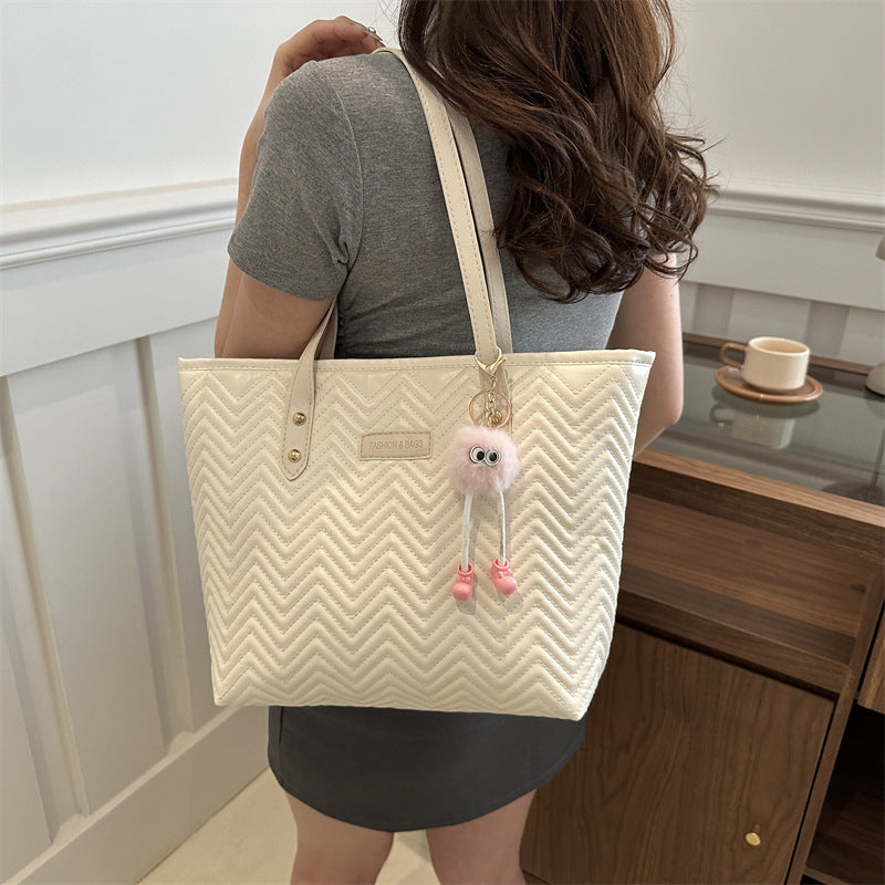 Women's leisure tote bag with textured wave pattern and charming pendant