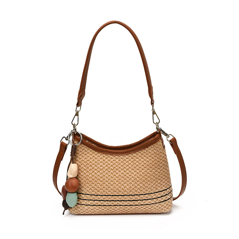 Women's shoulder bag made of woven natural material with decorative pendant