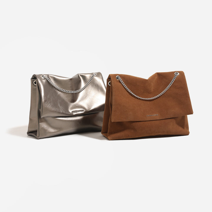 Women's clutch bag made of shiny synthetic leather with decorative chain strap