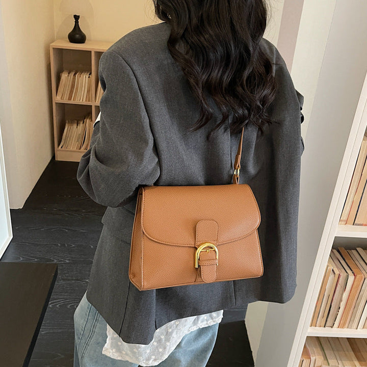 Ladies shoulder bag with elegant flap closure and decorative metal accent