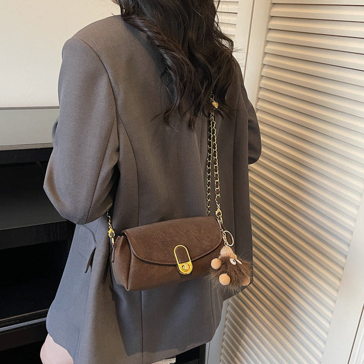 Women's shoulder bag with decorative pendant and luxurious chain strap