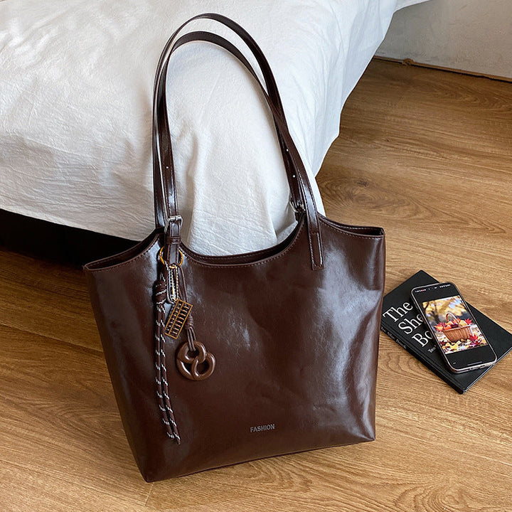 Ladies elegant tote handbag made of high-quality synthetic leather with playful pendant