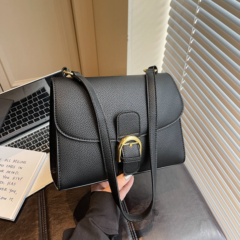 Ladies shoulder bag with elegant flap closure and decorative metal accent