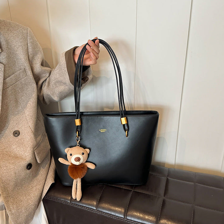 Women's tote bag made of high-quality artificial leather with a charming pendant from