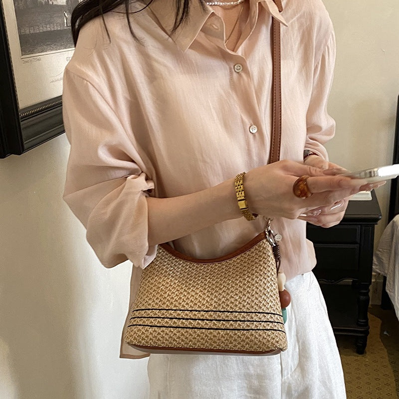 Women's shoulder bag made of woven natural material with decorative pendant