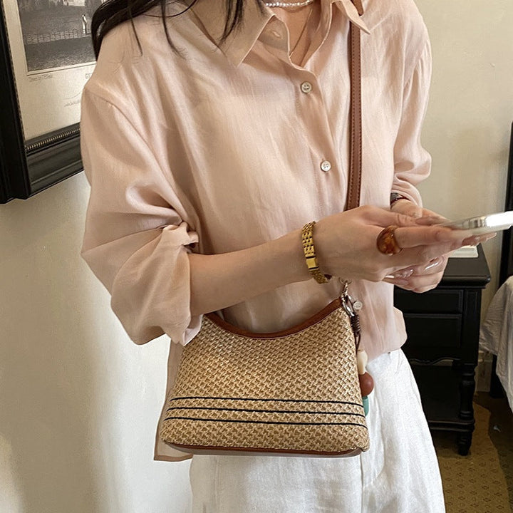 Women's shoulder bag made of woven natural material with decorative pendant