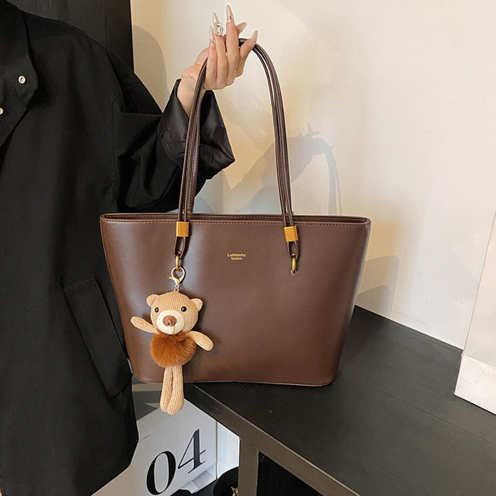 Women's tote bag made of high-quality artificial leather with a charming pendant from
