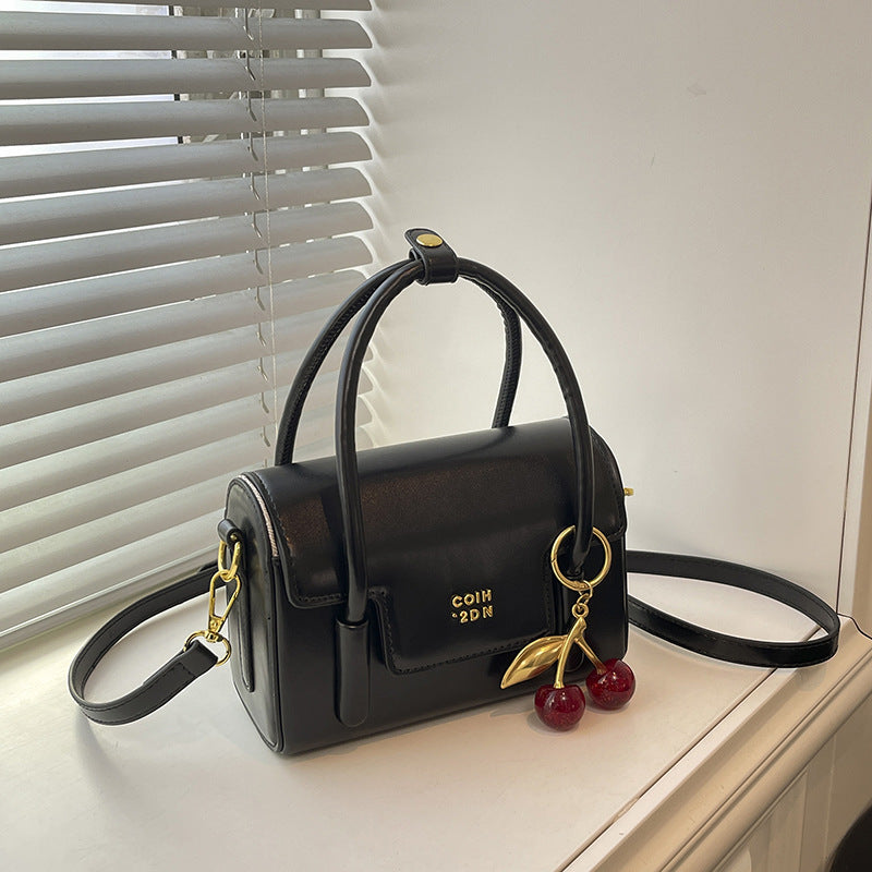Women's mini handbag with elegant structure and charming pendant