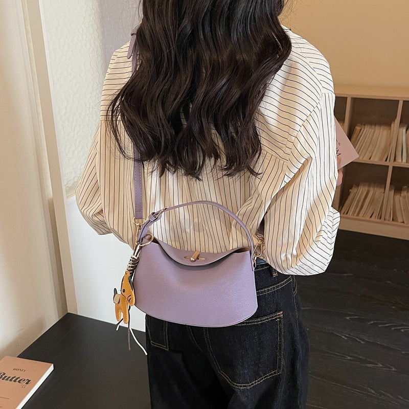 Women's shoulder bag with charming pendant and elegant design