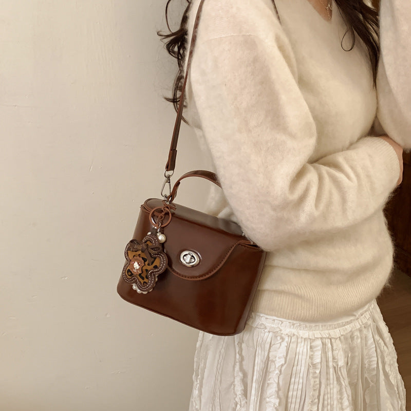 Ladies mini handbag in elegantly curved design with playful pendant