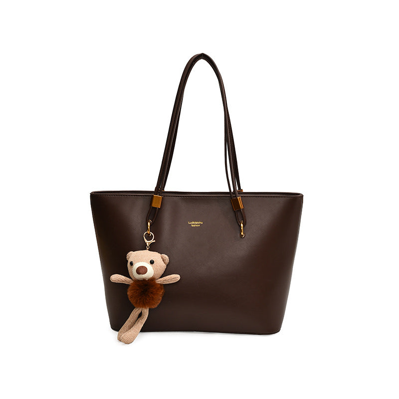 Women's tote bag made of high-quality artificial leather with a charming pendant from