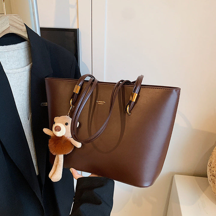 Women's tote bag made of high-quality artificial leather with a charming pendant from