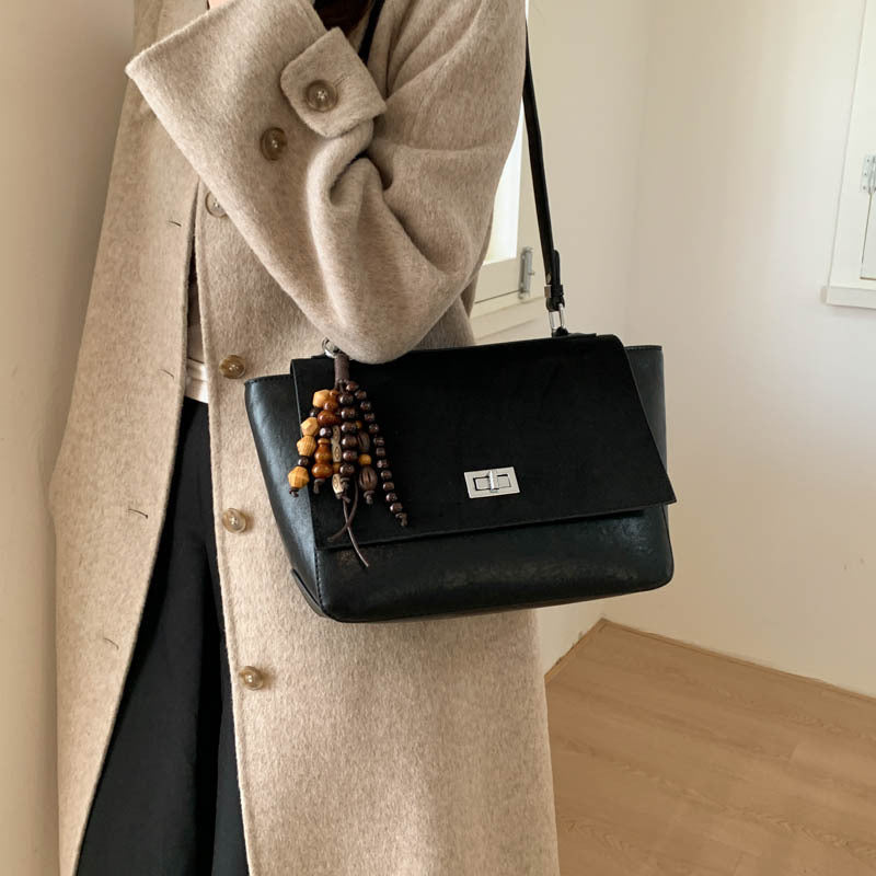 Women's elegant shoulder bag made of high-quality faux leather with playful charm