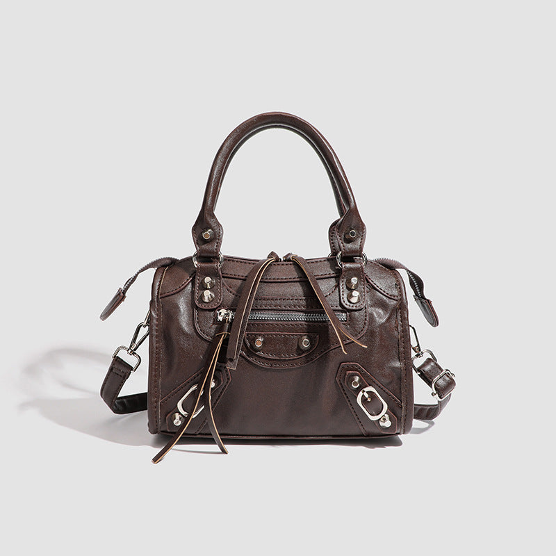 Women's mini handbag with decorative metal accents and removable shoulder strap