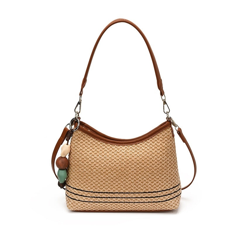 Women's shoulder bag made of woven natural material with decorative pendant
