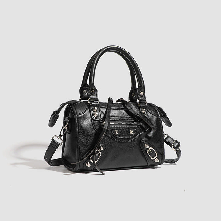 Women's mini handbag with decorative metal accents and removable shoulder strap